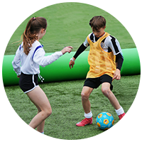 Kids playing small-sided football on AirPitch inflatable pitch in a backyard