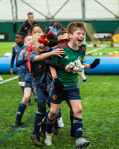 Manchester United Children celebrating a goal on the AirPitch inflatable football pitch during a grassroots tournament